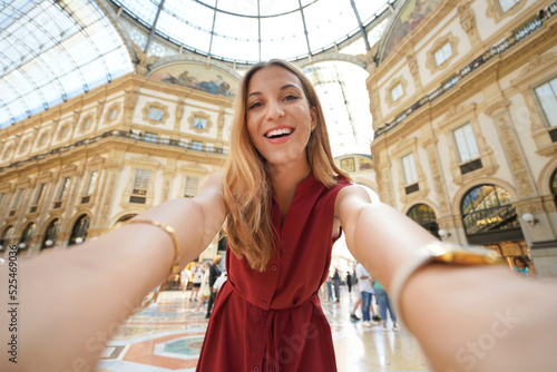 Smiling fashion girl takes self portrait in Milan shopping gallery and landmark  Milan  Italy