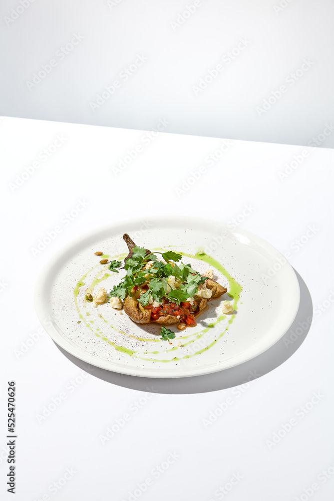 Baked eggplant with cheese on white table with harsh shadows. Aesthetic italian food - baked aubergine on white plate. Stuffed eggplant in minimal style. Stuffed aubergine in vegan menu. Baked eggplant with cheese on white table with harsh shadows. Aesthetic italian food - baked aubergine on white plate. Stuffed eggplant in minimal style. Stuffed aubergine in vegan menu.