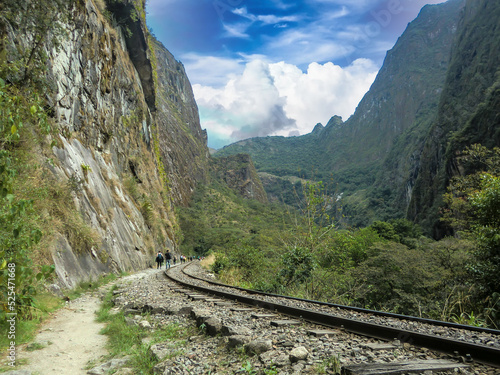 Tracks of a train in the middle of a jungle and mountains, on the way to the citadel of Machu Picchu, Cusco - Peru.