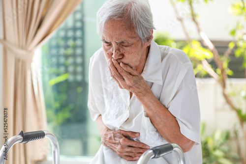 Foto Asian senior woman suffering from abdominal bloating,colic in abdomen,flatulence
