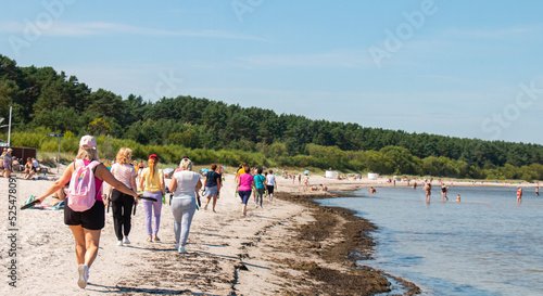 sports group walking on the sandy seashore, Europe, Baltic.