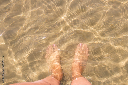 Women's legs, relaxation in the sea wave. Summer vacation concept © Inga