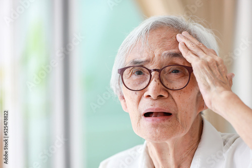 Forgetful asian senior woman with amnesia,brain disease,patient holding head with her hand,suffering from senile dementia,memory disorders,confused old elderly with Alzheimer's disease,health problems