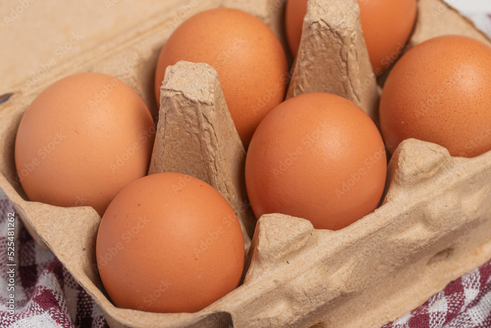 A cardboard box full of fresh chicken eggs on a white background. A cardboard box full of fresh chicken eggs on a white background.