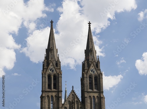 The tower of the church of St. Ludmila, in the background a blue sky with white clouds. Peace Square, Prague, Czech Republic.