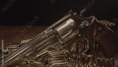 Dolly in of beautiful .357 magnum revolver surrounded by shining cartridges photo