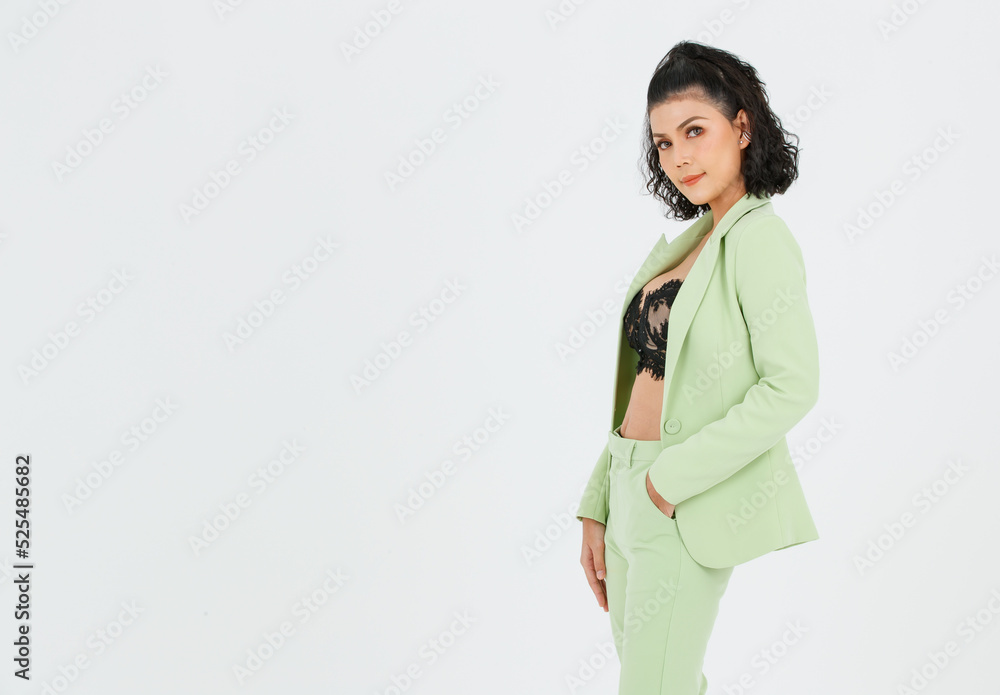 Portrait isolated cutout studio shot of Asian sexy curly hair fashion businesswoman in green suit with black lace lingerie crop top bra standing posing put hands in pants pockets on white background Portrait isolated cutout studio shot of Asian sexy curly hair fashion businesswoman in green suit with black lace lingerie crop top bra standing posing put hands in pants pockets on white background