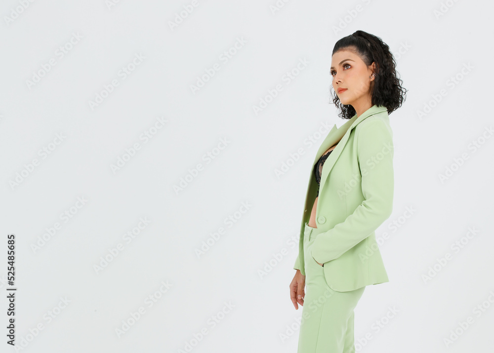 Portrait isolated cutout studio shot of Asian sexy curly hair fashion businesswoman in green suit with black lace lingerie crop top bra standing posing put hands in pants pockets on white background Portrait isolated cutout studio shot of Asian sexy curly hair fashion businesswoman in green suit with black lace lingerie crop top bra standing posing put hands in pants pockets on white background