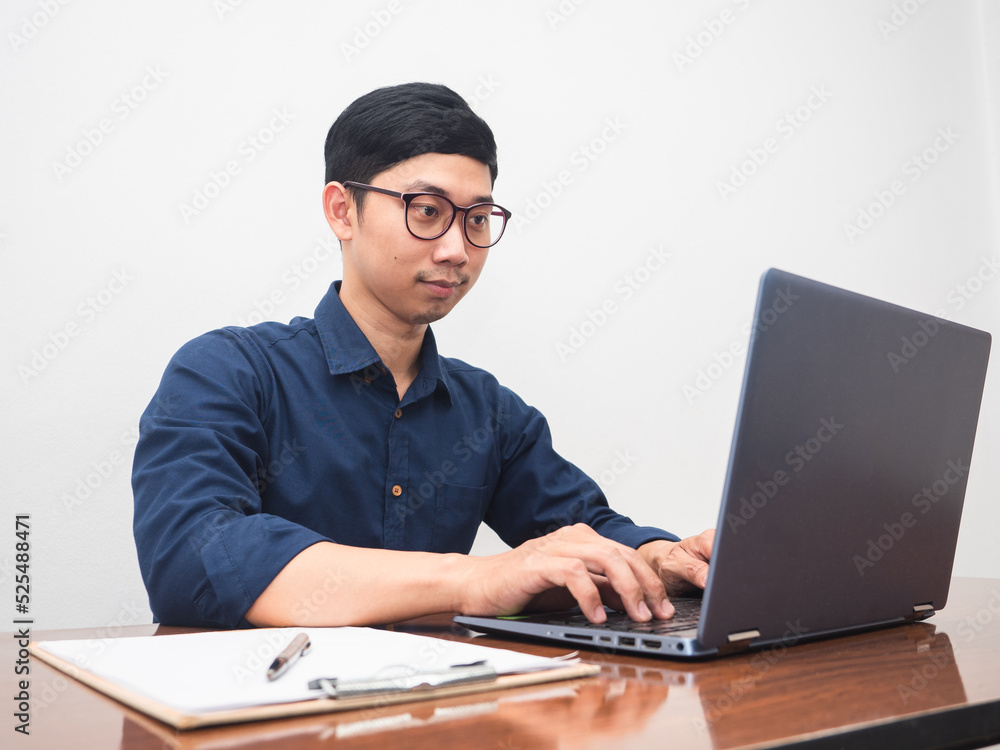 Businessman using laptop at workplace table in the room Businessman using laptop at workplace table in the room