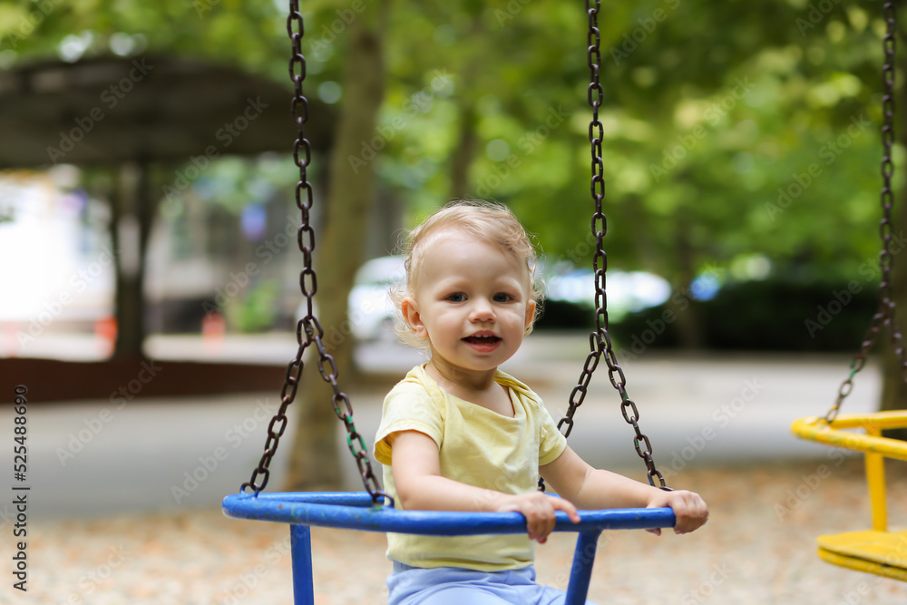 Blurred happy girl in motion swinging on a swing Blurred happy girl in motion swinging on a swing