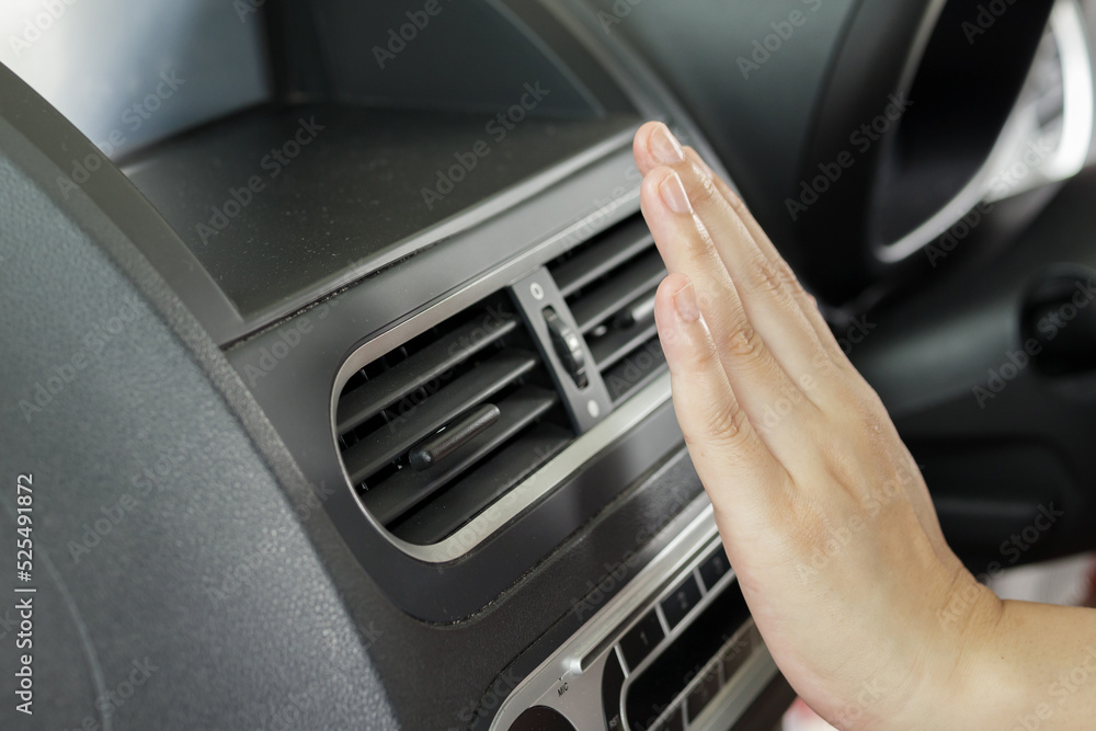 hand checking air conditioner system inside the car