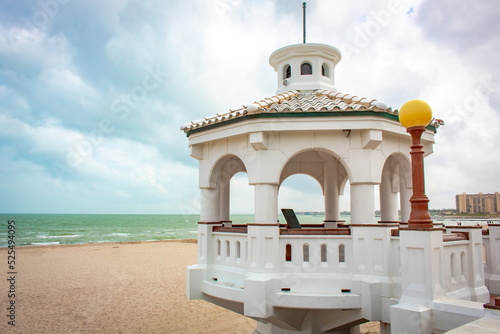 White pavilion at the beach and bay in Corpus Christi Texas on a blue cloudy day