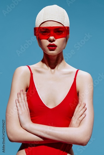 A girl with a MarsaY in a red swimsuit with glasses folding her hands looks at the camera. The art of the new generation of NFT