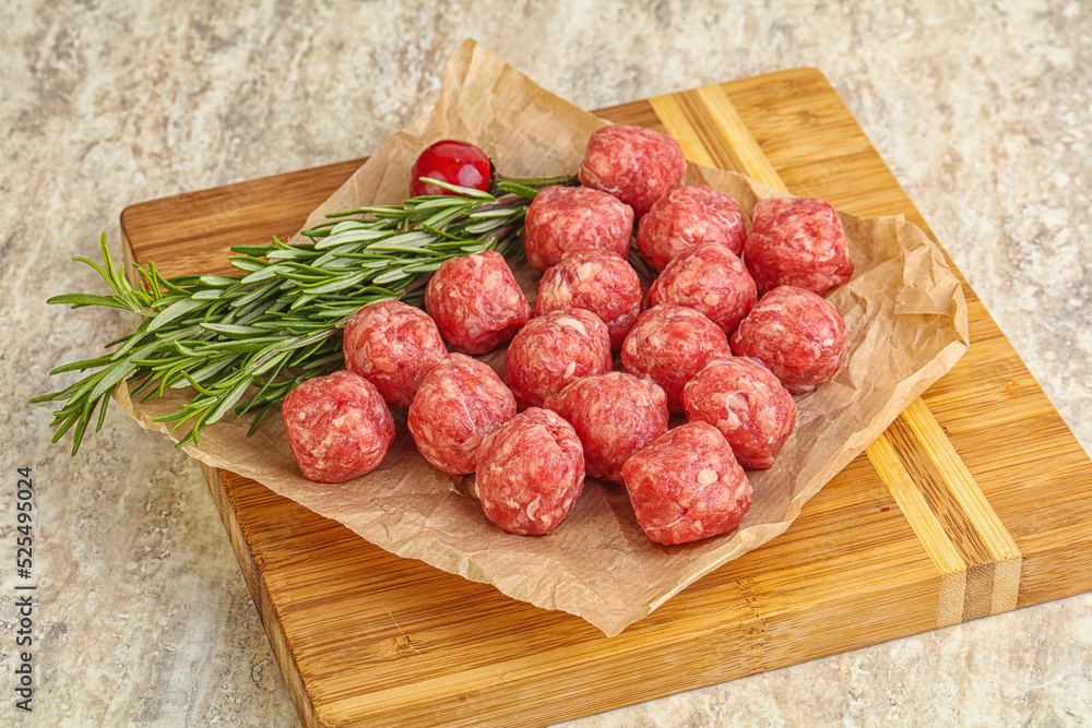 Raw uncooked beef meatballs served rosemary Raw uncooked beef meatballs served rosemary