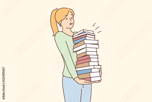 Young woman carrying pile of books