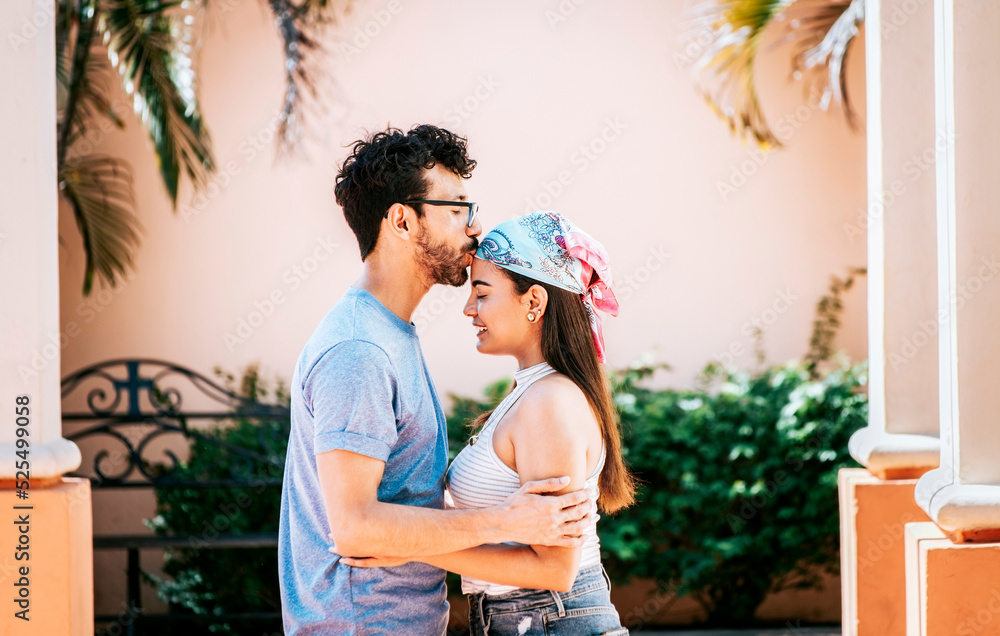 Man kissing his girlfriend forehead outside. Cute couple embracing the ...