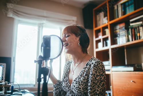 Singer performing song into microphone at home