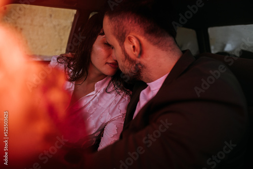 Newlywed couple kissing inside a car photo
