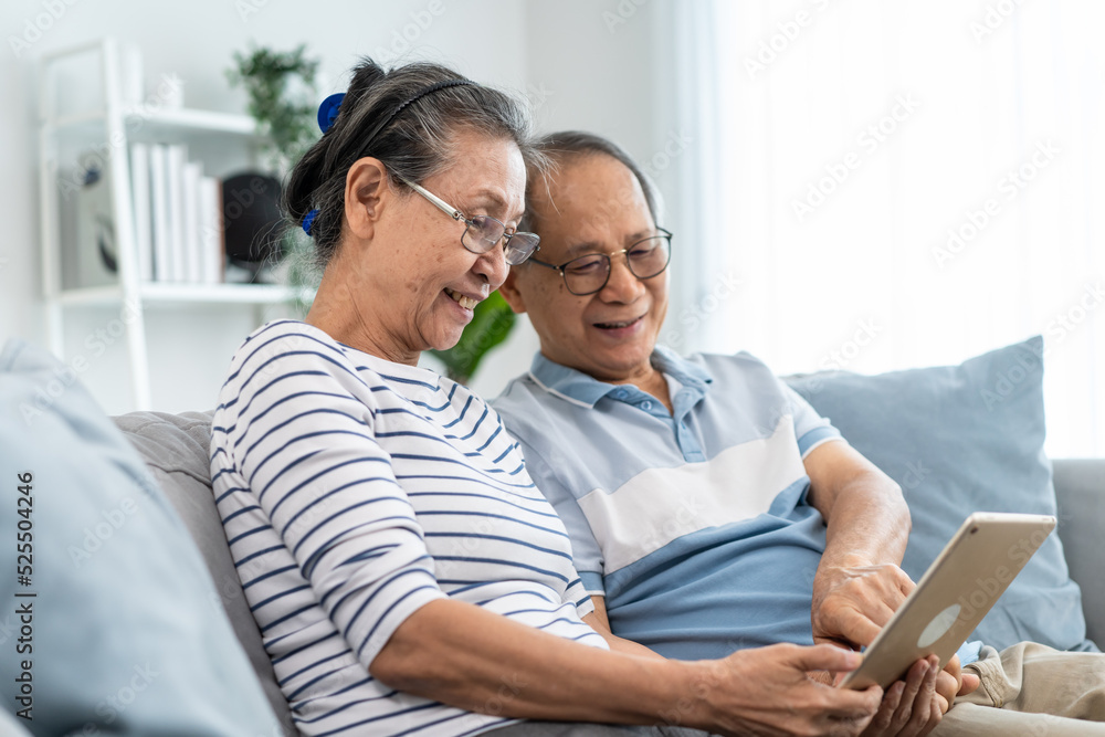 Asian senior elderly man and woman holding and using tablet at home. Asian senior elderly man and woman holding and using tablet at home.