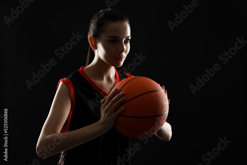 Basketball player with ball on black background © New Africa