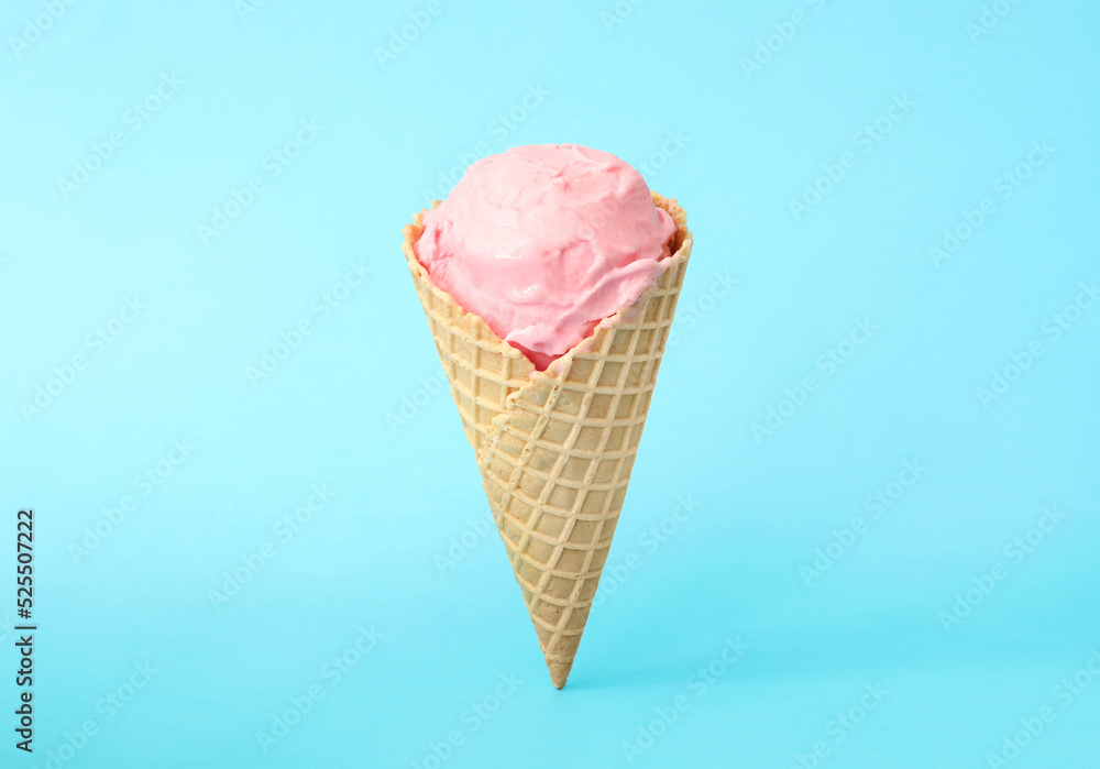 Delicious pink ice cream in waffle cone on light blue background Delicious pink ice cream in waffle cone on light blue background
