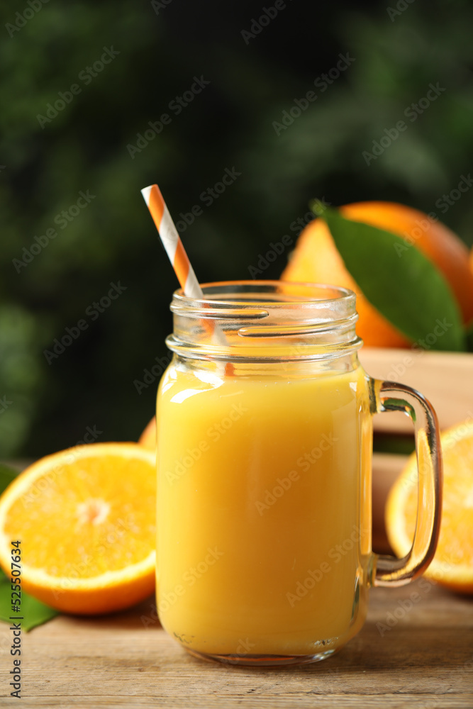 Mason jar of orange juice and fresh fruits on wooden table Mason jar of orange juice and fresh fruits on wooden table