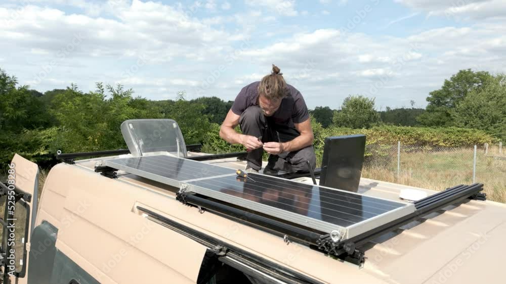 Man working on the roof of his camper van Man working on the roof of his camper van