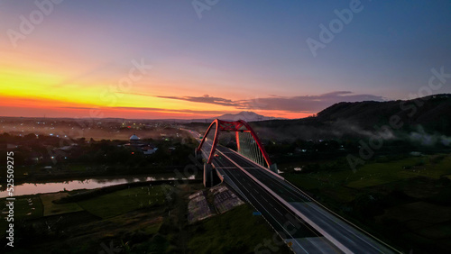 Aerial view of the Kalikuto Bridge, an Iconic Red Bridge at Trans Java Toll Road, Batang when sunrise. Central Java, Indonesia, August 24, 2022