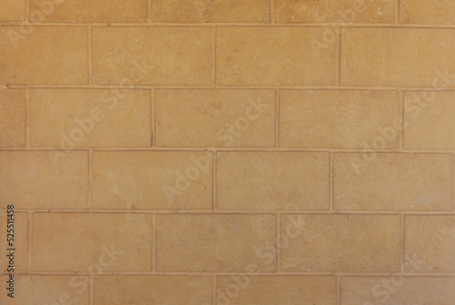 Decorative large brick wall close up in beige brown colors. Abstract texture. Horizontal brick tile background.