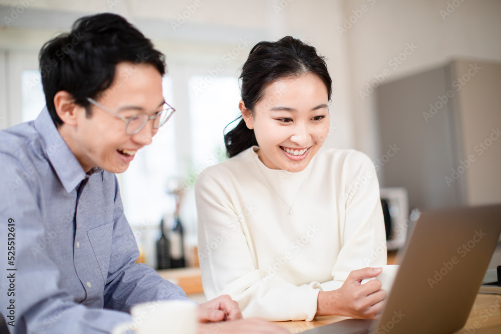 パソコンを眺める夫婦