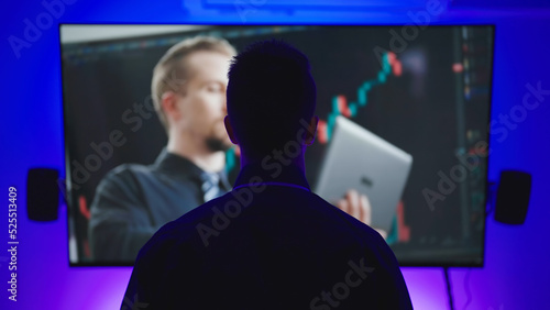 Male person silhouette absorbed in watching different media on big TV screen