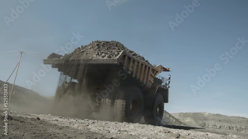 Mining dump truck leaves the place of loading with a full body of coal photo