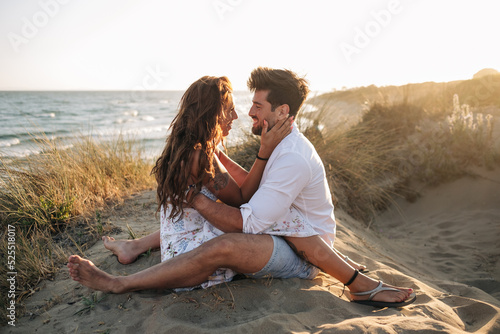 Loving couple hugging and looking at each other on seashore on s photo