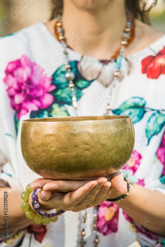 Detail of a woman's hands holding a Tibetan singing bowl.