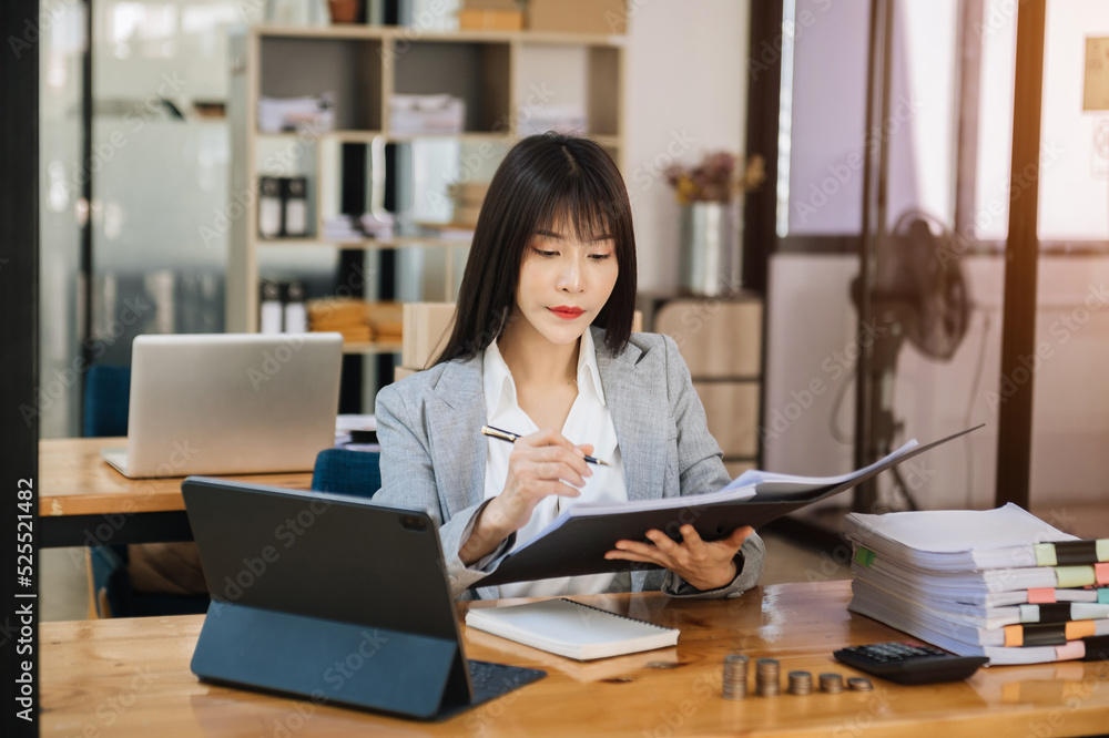 Young beautiful woman using laptop and tablet while sitting at her working place. Concentrated at work.. Young beautiful woman using laptop and tablet while sitting at her working place. Concentrated at work..