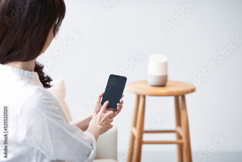 スマートスピーカーとスマートフォンと女性の手