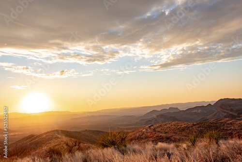 Dramatic golden sky sunset clouds over the grass fields and desert of Big Bend National Park Texas