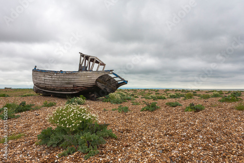 Fishing boat abandoned on the shingle beach at Dungeness, Kent, UK photo