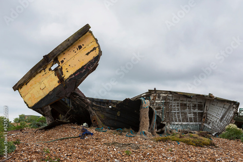 The wreck of an old wooden fishing boat on the shingle beach at Dungeness, Kent, UK photo