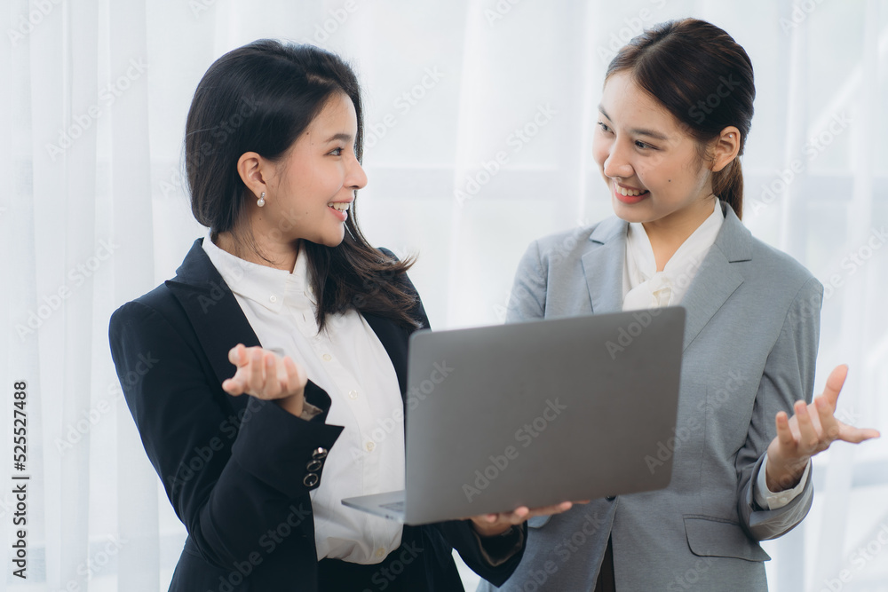 Two asian business woman work together to get the job done at the office. Two asian business woman work together to get the job done at the office.