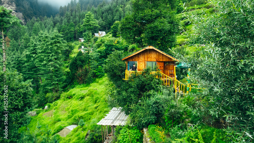 Photos male tourist on balcony of beautiful wooden tiny treehouse in the mountains of J