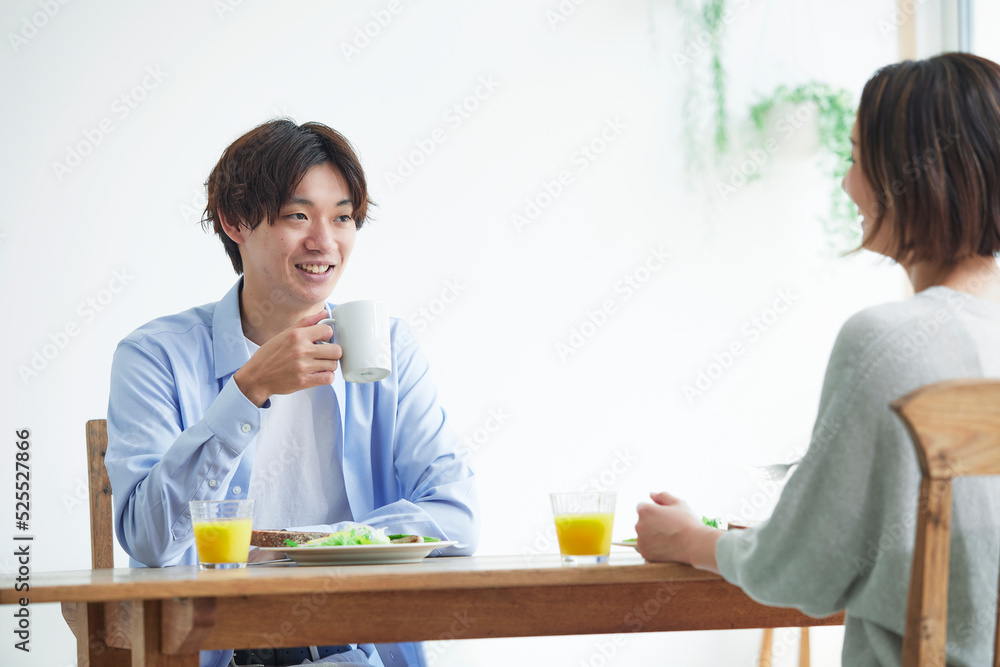 リビングで食事をする若い男性と女性 リビングで食事をする若い男性と女性