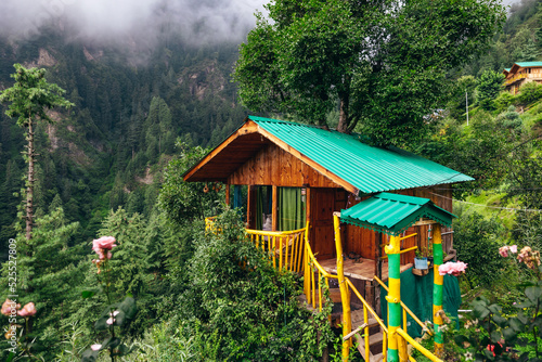 Magical wooden treehouse in the mountains of Jibhi India with moody clouds and cedar trees  photo