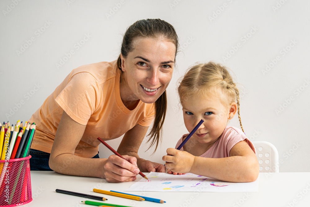 Smiling girl child and mother are painted with colored pencils on paper Smiling girl child and mother are painted with colored pencils on paper