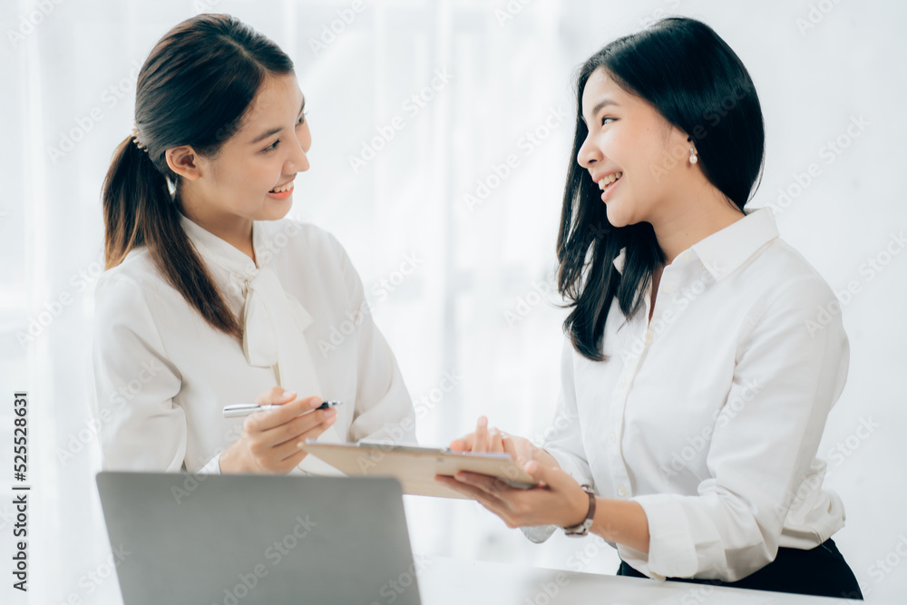Two business Asian young women working together with laptop computer in the modern office. Two business Asian young women working together with laptop computer in the modern office.