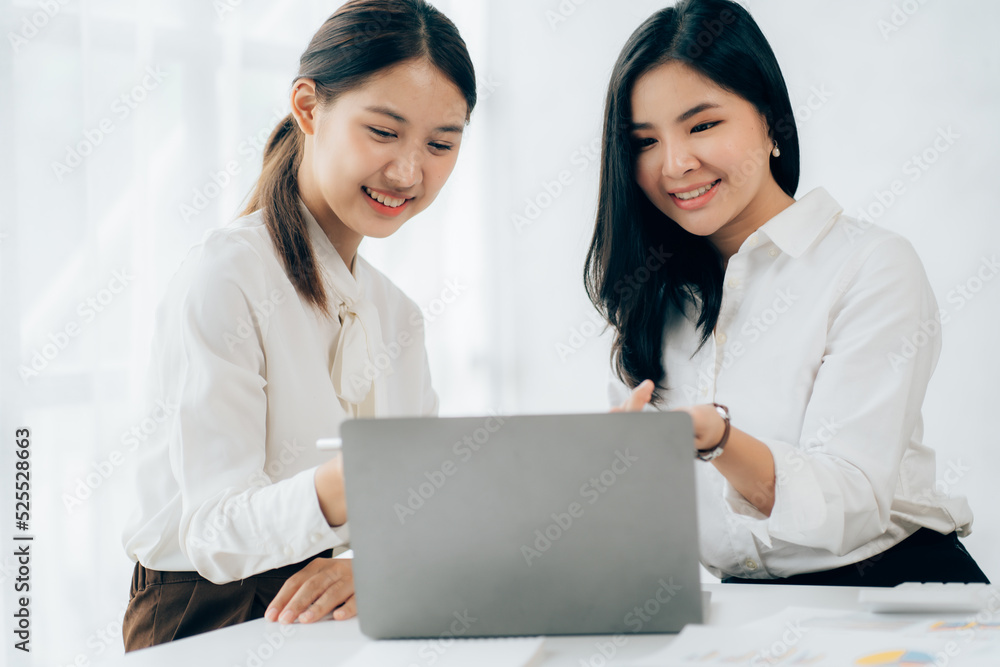 Two business Asian young women working together with laptop computer in the modern office. Two business Asian young women working together with laptop computer in the modern office.