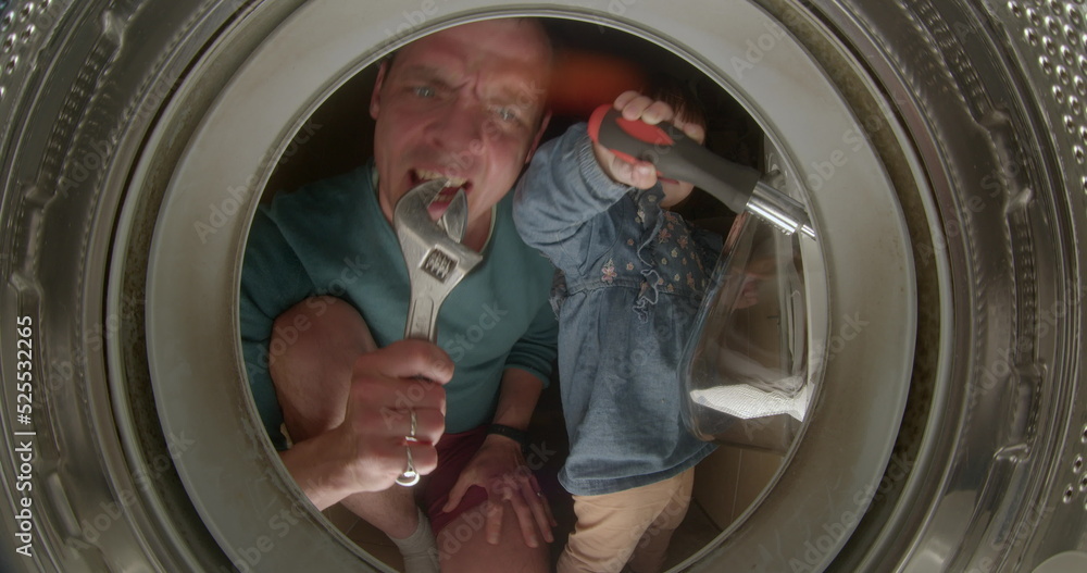Dad sings a song to a wrench with a board in a washing machine drum. He emits a microphone, the girl sings. Motivation with the support of a young father, repair. Dad sings a song to a wrench with a board in a washing machine drum. He emits a microphone, the girl sings. Motivation with the support of a young father, repair.