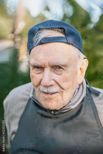 Portrait of a cheerful 88-year-old man in a baseball cap. Happy active old age