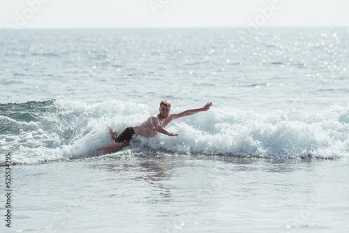 Young man doing a belly flop at beach