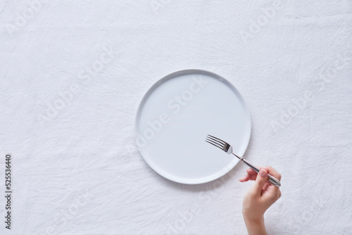 白い皿とフォークを持つ女性の手 photo